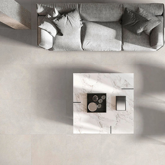 Ceramica Valsecchia Capital 'Ice', vloertegels 60x60 van bovenaf in een woonkamer met grijze bank en marmeren salontafel