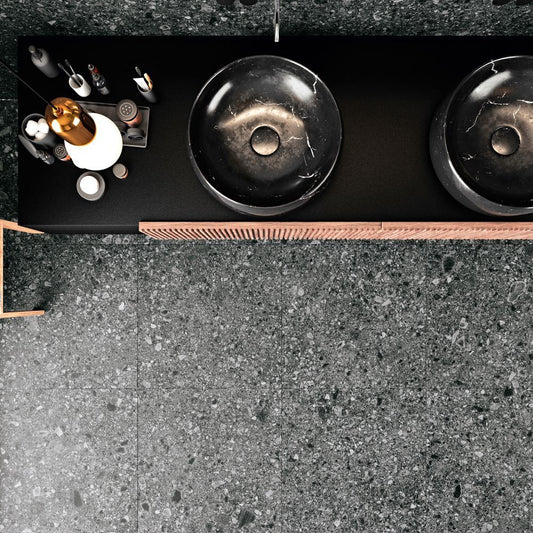 Tuscania Ceppo di Gré 'Anthracite', donkergrijze terrazzo vloertegels met een zwart wastafelblad en twee ronde waskommen