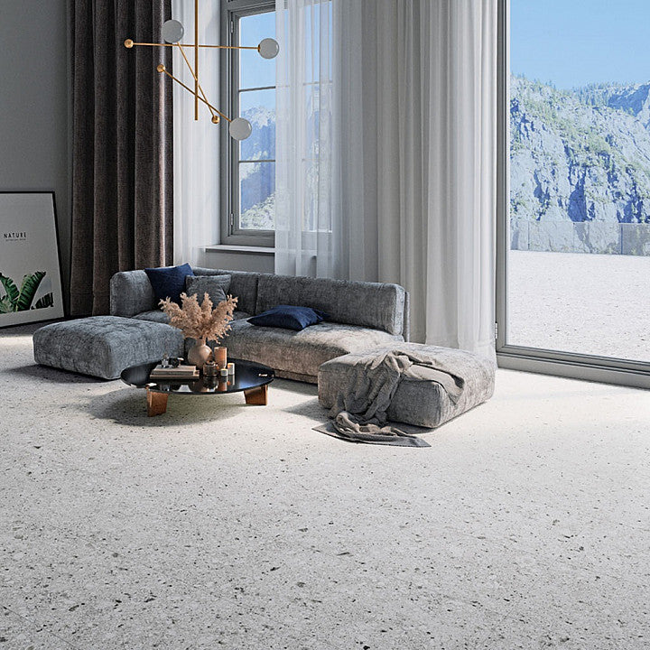Tuscania Ceppo di Gré 'White', witte terrazzo vloertegels in een woonkamer met loungebank en uitzicht op besneeuwde bergen