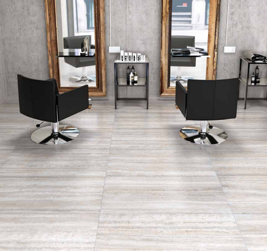 Tuscania Dolomia Stone 'White Vein', lichtgrijze travertijnlook vloertegels in een kapsalon met zwarte stoelen en spiegels