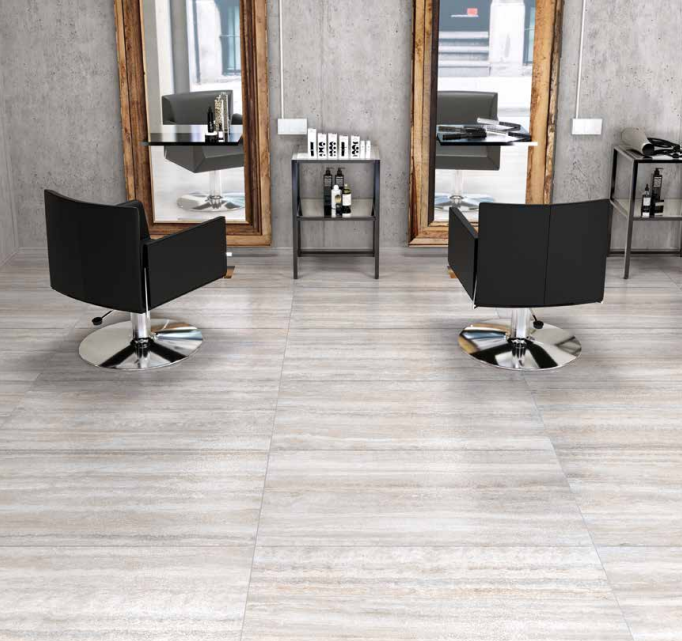 Tuscania Dolomia Stone 'White Vein', lichtgrijze travertijnlook vloertegels in een kapsalon met zwarte stoelen en spiegels