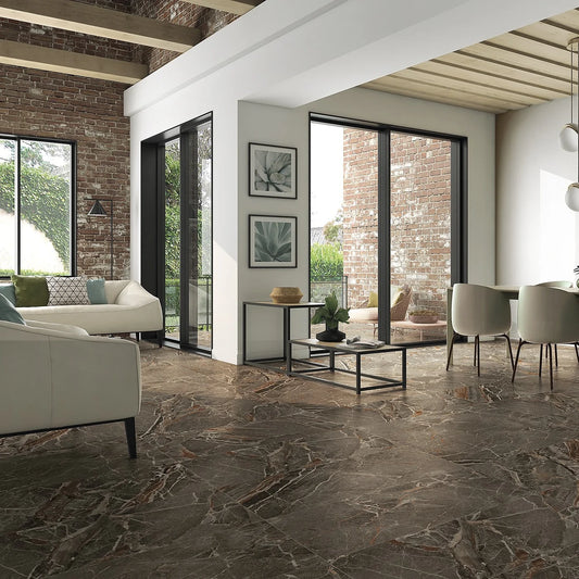 La Platera Dusk 'Taupe', taupe marmerlook vloertegels 60x120cm in een open woonruimte met bakstenen muren en zithoek