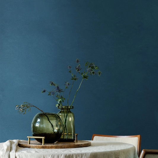 EnergieKer Mood 'Vivo', donkerblauwe wand van 120x280cm platen achter een ronde tafel met glazen vazen