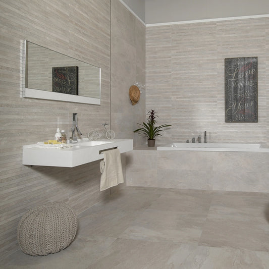 Keraben Nature 'Bone', crème-witte wandtegels 30x90 in een badkamer met wastafel, bad en poef