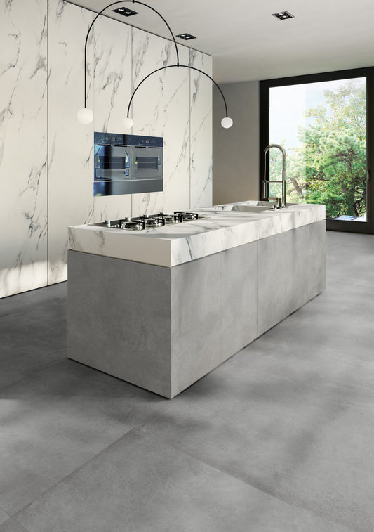 EnergieKer Parker 'Grey', grijze betonlook vloertegels in een keuken met kookeiland en witte marmerlook achterwand