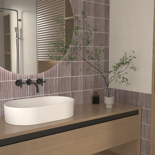 Estudio Cerámico Shallow 'Aubergine', paarse ribbeltegels 14,7x14,7 in een badkamer met ronde spiegel en waskom