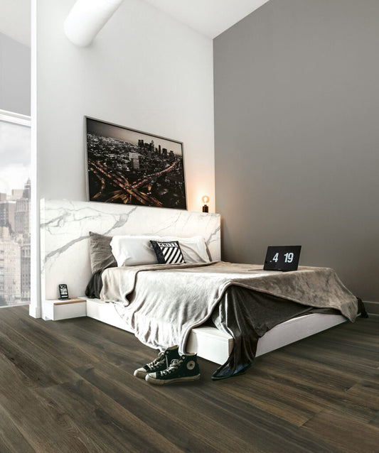 EnergieKer Woodbreak 'Mahogany', donkerbruine houtlook vloertegels in een slaapkamer met marmeren hoofdbord en stadsfoto