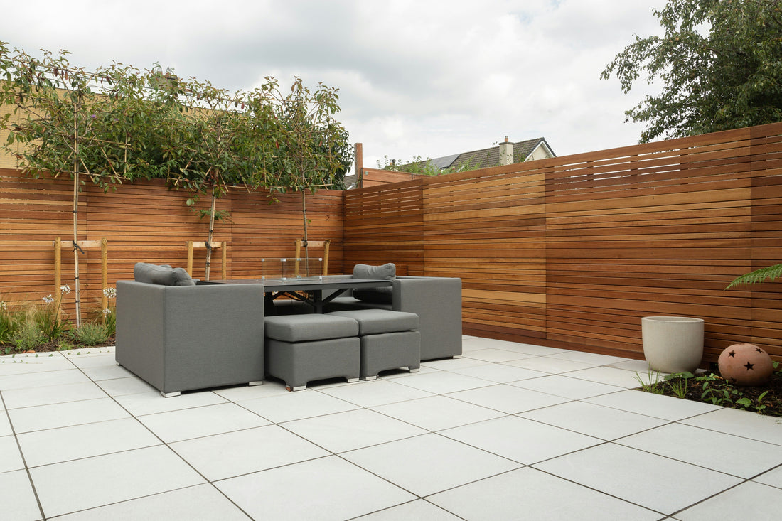 Keramische terrastegels met houten schutting in een tuin