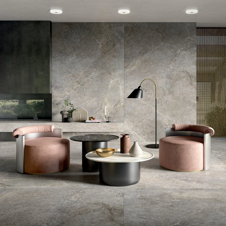 Anthology van Lea Ceramiche, grijze betonlook wandtegels in een lounge met ronde tafels
