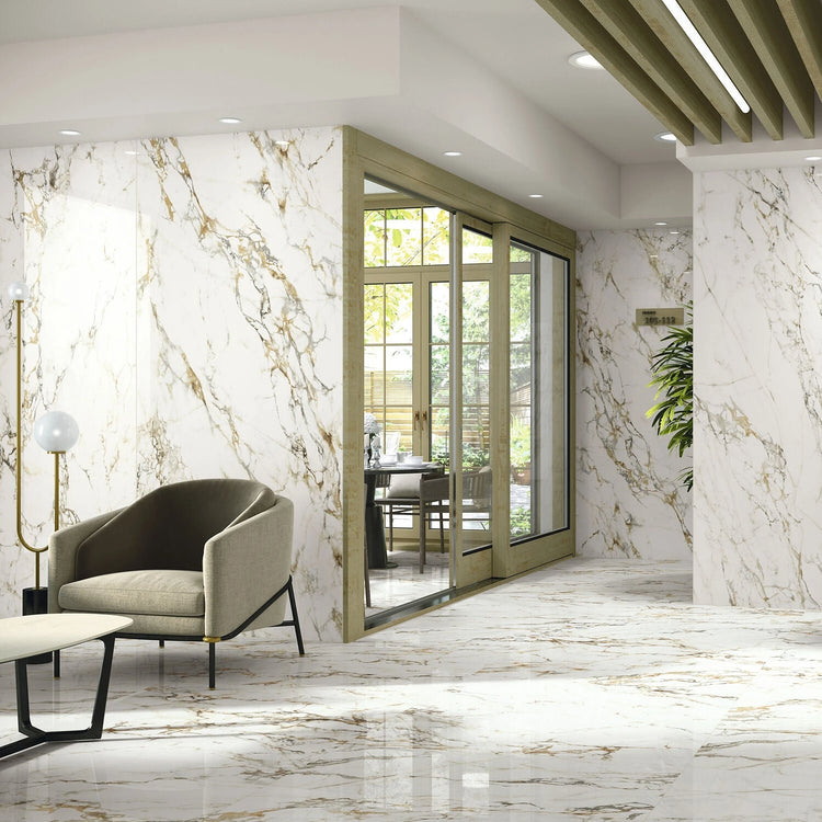 Bellagio van Baldocer Cerámica, witte marmerlook tegels in een lichte ruimte met groene fauteuil