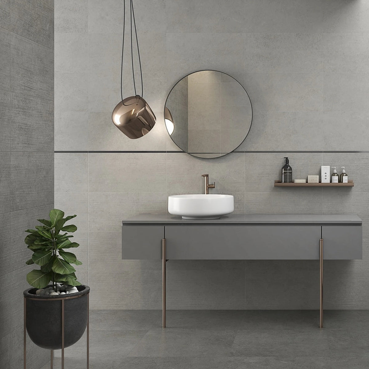 Grijze betonlook wandtegels in een badkamer met wastafel en vrijstaand bad