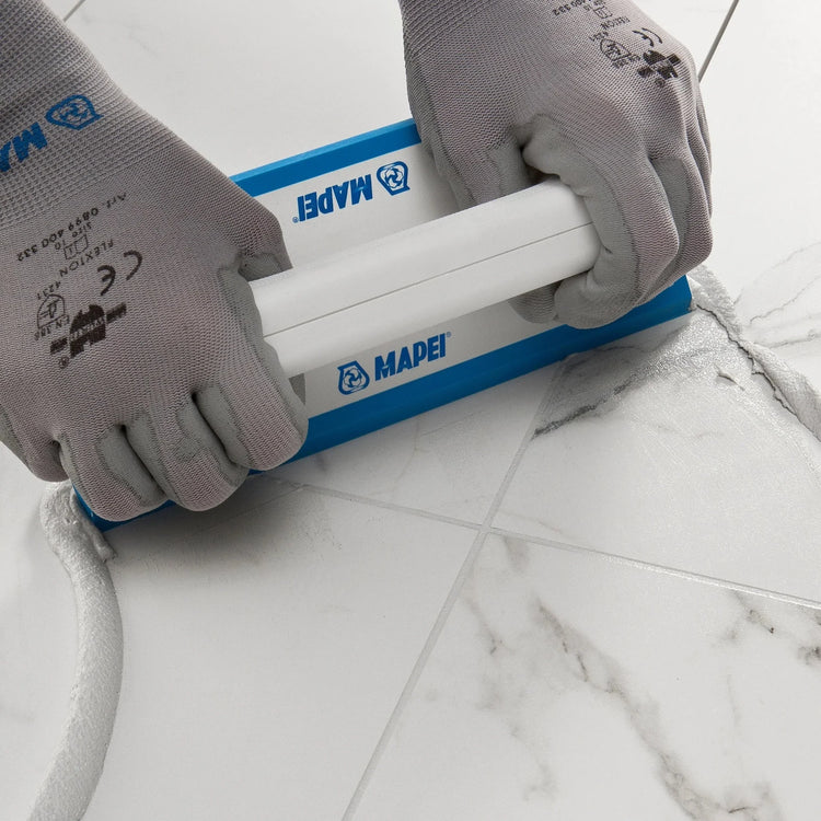 Cementgebonden voegmiddel aanbrengen tussen witte marmerlook tegels met een koker
