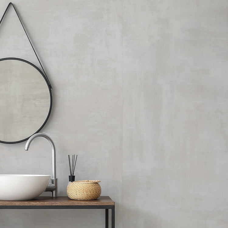 Concept van EnergieKer, lichtgrijze betonlook wandtegels in een badkamer met ronde spiegel