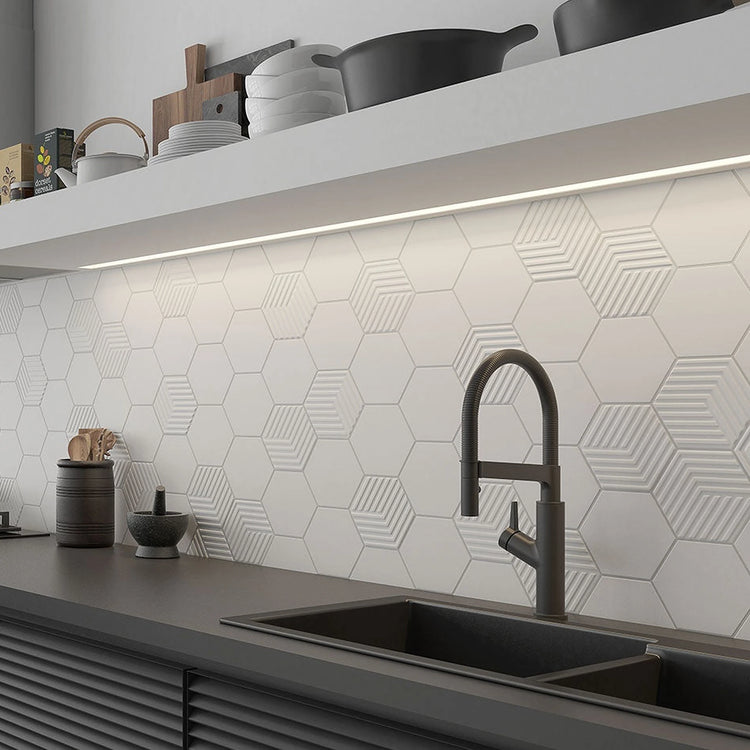 Witte hexagon wandtegels met kubusreliëf als keukenachterwand boven een zwarte keuken