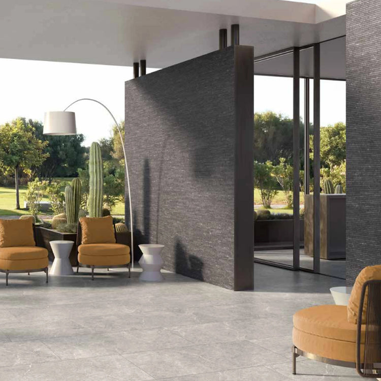 Holy stone van Tuscania, natuursteenlook vloertegels op een overdekte veranda met doorkijk naar de tuin
