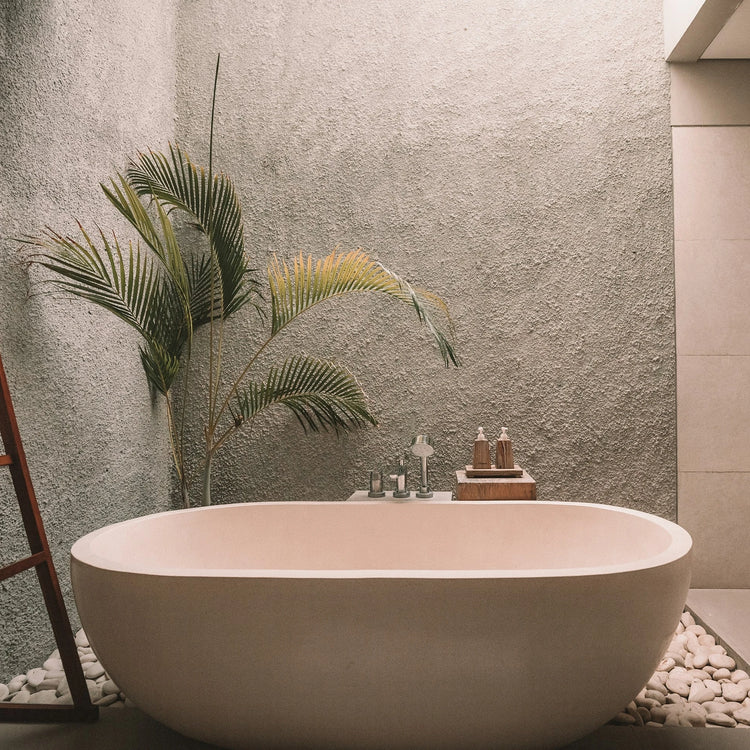 Japandi-badkamer met beige tegels, vrijstaand bad en een grote plant