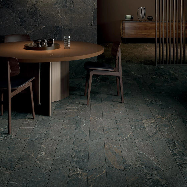 Kalksteenlook vloertegels in een donkere ruimte met ronde tafel en bollamp