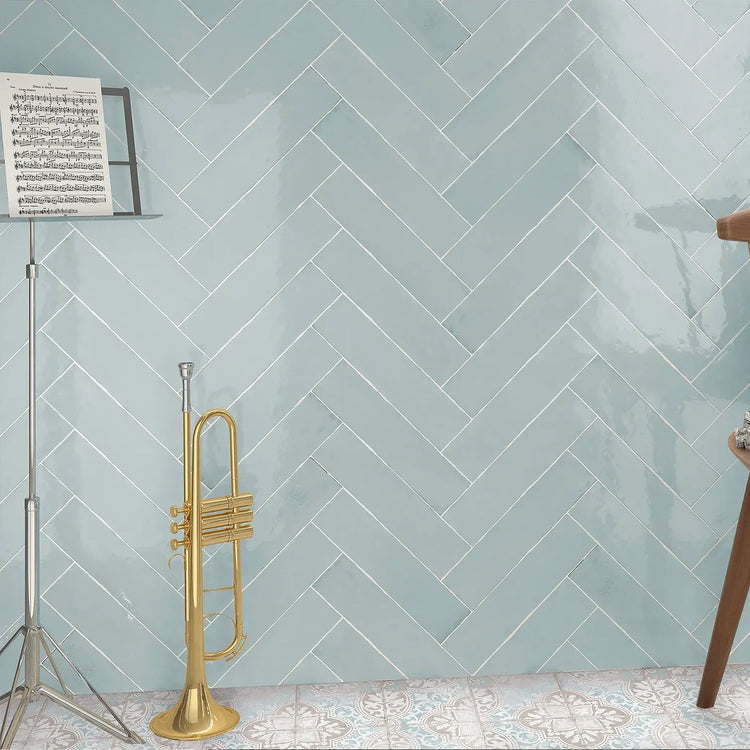 Estudio Cerámico Ondine, blauwe glanzende wandtegels in visgraatverband met een trompet en muziekstandaard
