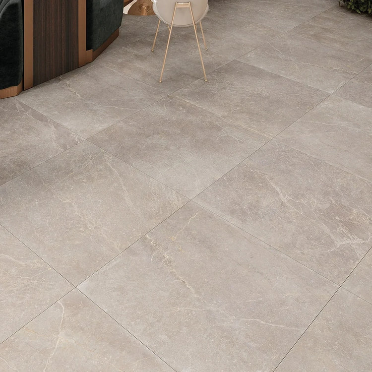 Grote beige vloertegels met natuursteenlook in een lichte, sobere ruimte