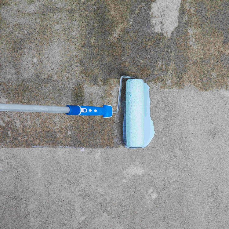 Blauwe roller die voorstrijkmiddel aanbrengt op een grijze ondergrond
