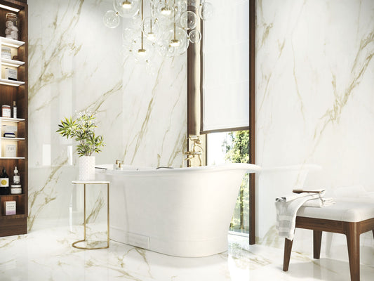 Baldocer Cerámica Adaggio 'Adaggio Gold', witte marmerlook wand- en vloertegels met goudbeige adering in een badkamer met bad