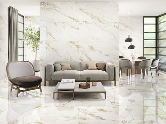 Baldocer Cerámica Adaggio 'Adaggio Gold', witte marmerlook wand en vloer met goudbeige adering in een woonkamer met bank