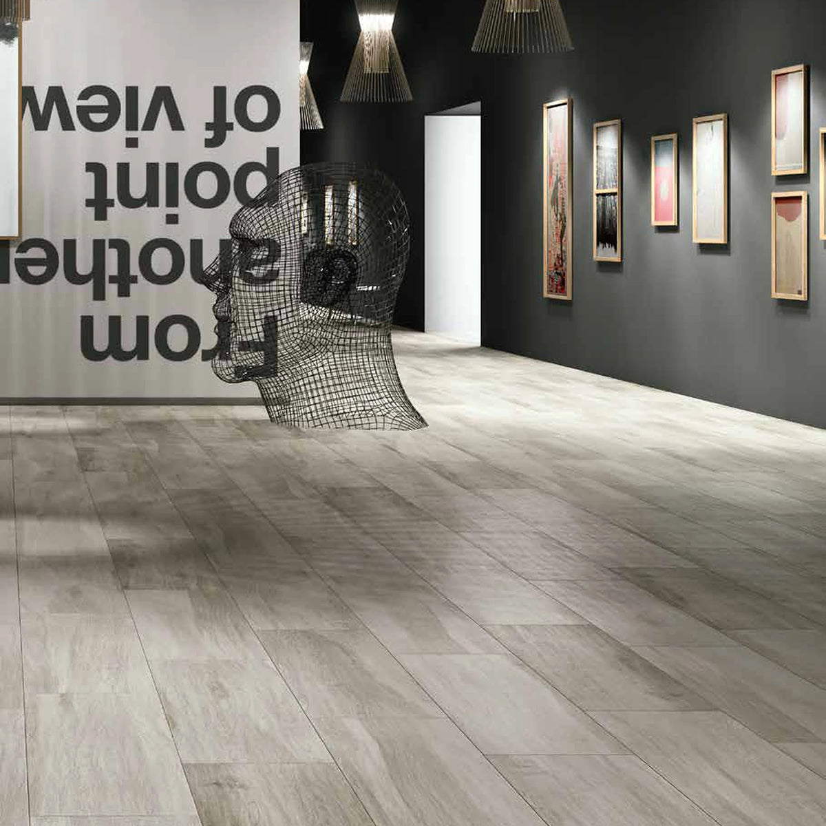 Castelvetro Aequa 'Cirrus Grip', grijze houtlook vloertegels, hier 30x120cm, in een galerie met tekstposter en draadsculptuur