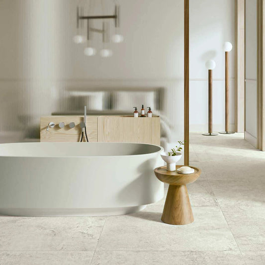 Castelvetro Always 'Bianco', witte vloertegels 100x100 in een lichte badkamer met vrijstaand bad
