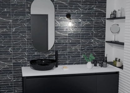 Estudio Cerámico Argos 'Marquina', zwarte marmerlook wandtegels met verticaal reliëf in een badkamer met spiegel en waskom