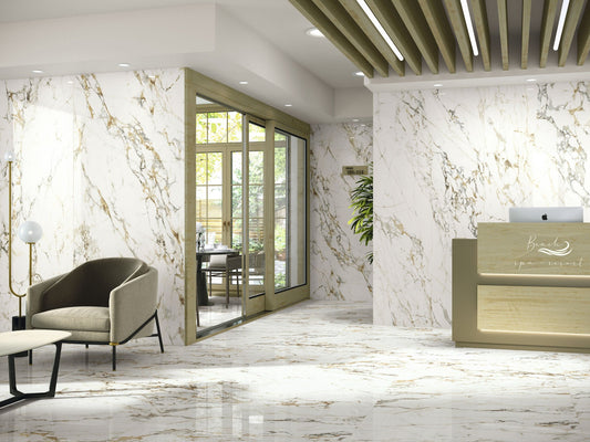 Baldocer Cerámica Bellagio, witte marmerlook wand en vloer met goudbruine adering in een ontvangsthal met balie en fauteuil