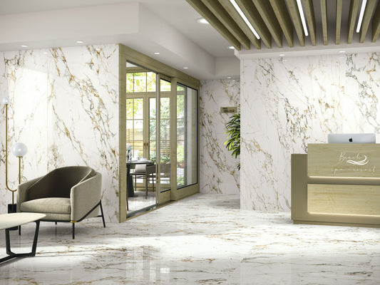 Baldocer Cerámica Bellagio, witte marmerlook wand en vloer met goudbruine adering in een ontvangsthal met balie en fauteuil