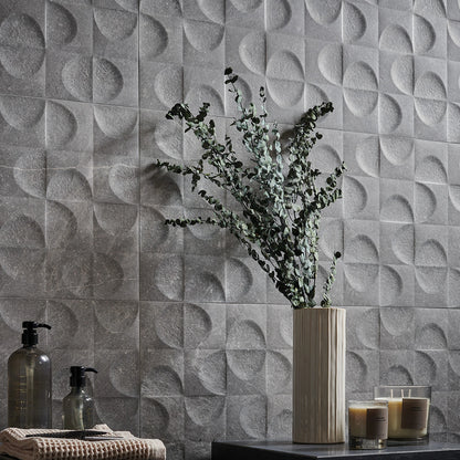 Keraben Bleuemix 'Grey', grijze wandtegels, hier met reliëf Concept, achter een vaas met eucalyptus