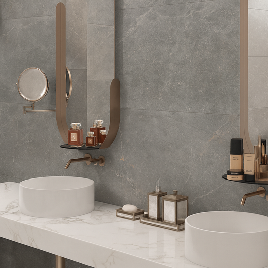 Keraben Bleuemix 'Grey Soft', grijze marmerlook wandtegels in een badkamer met twee ronde witte opzetkommen en bronzen kranen
