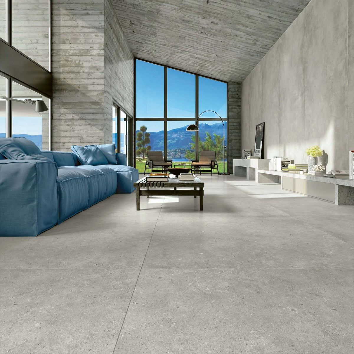 EnergieKer Brera 'Street', vloertegels 120x120cm in een hoge woonkamer met blauwe bank en bergzicht