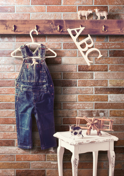 Ceramica Rondine Bristol 'Rust', bruine baksteenlook tegels in een kinderkamer met kapstok, tuinbroek en ABC-letters