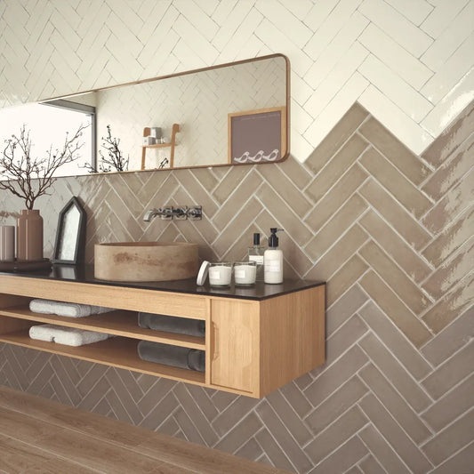 Estudio Cerámico Camden 'Toffee', beige wandtegels in visgraatverband in een badkamer met wastafelmeubel en stenen waskom