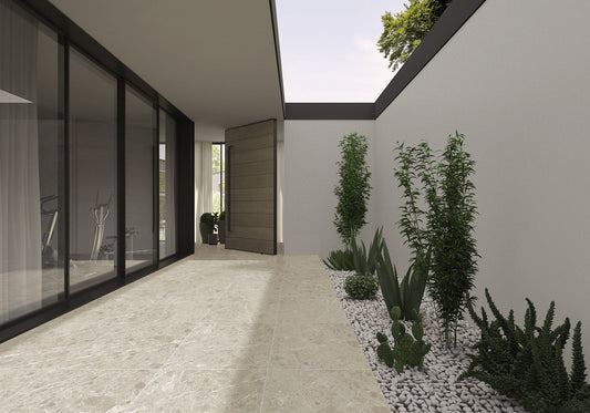 La Platera Caprice 'Beige', beige marmerlook vloertegels 60x120cm in een patio langs een glazen pui met beplanting