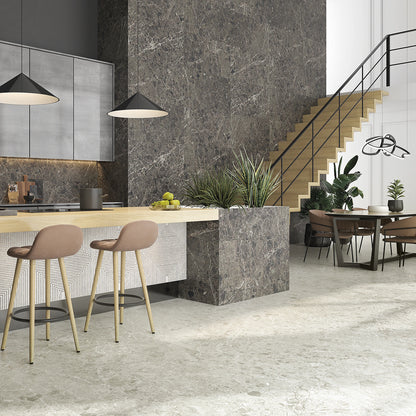 La Platera Caprice 'Black', donkere marmerlook wandtegels, hier 60x120cm, achter een keukeneiland met roze barkrukken