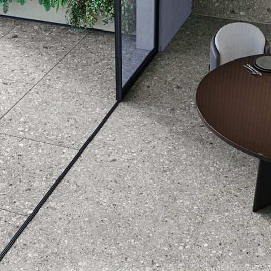 Tuscania Ceppo di Gré 'Natural', lichtgrijze terrazzo vloertegels die door een glazen pui van binnen naar buiten doorlopen