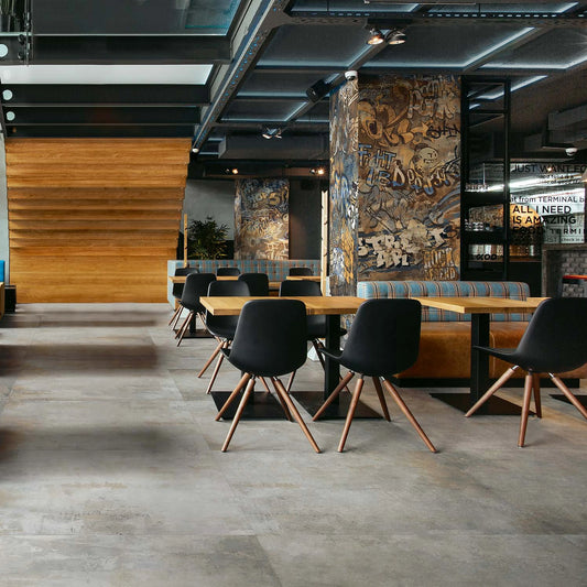 EnergieKer City Plaster 'Grey', grijze vloertegels 120x120cm in een restaurant met zuilen in graffitidecor