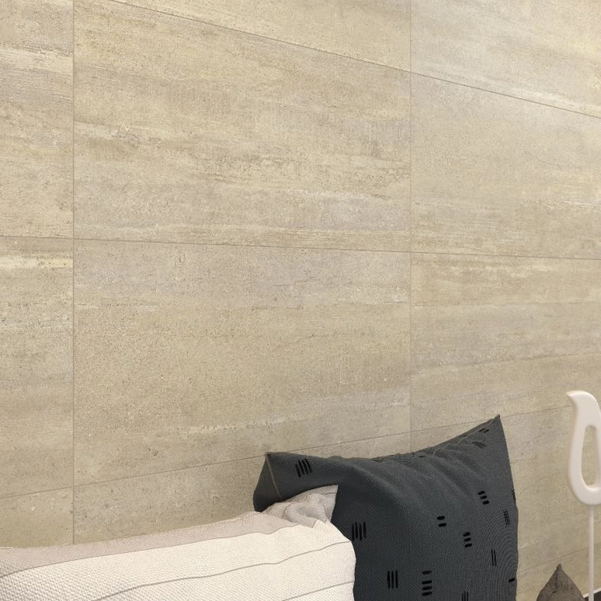 Castelvetro Concept 'Deck Ivory', crèmekleurige wandtegels, hier 40x80cm, boven een bed met donker kussen