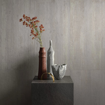 Castelvetro Concept 'Deck Light Grey', lichtgrijze wandtegels, hier 60x120cm, bij een rode vaas op een donker blok