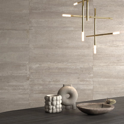 Castelvetro Concept 'Deck Muddy', taupe wandtegels, hier 60x120cm, bij een gouden hanglamp en beige vazen