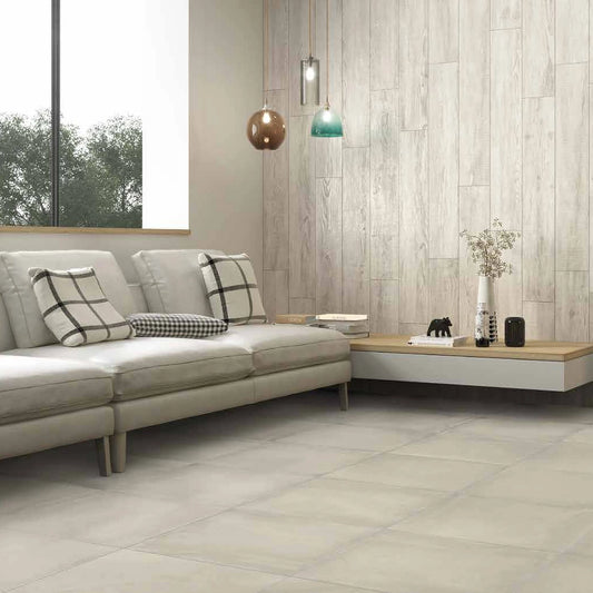 Castelvetro Concept 'Land White', witte vloertegels 60x60cm in een woonkamer met bank en een wand in houtlook