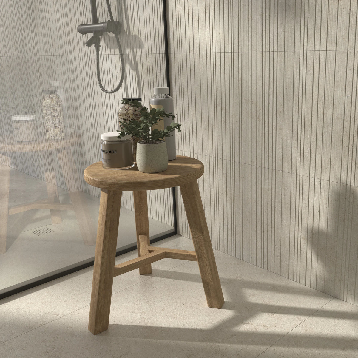 Cifre Cronos 'Cream', douche met crème vloer, Laja-reliëf op de wand en een houten krukje