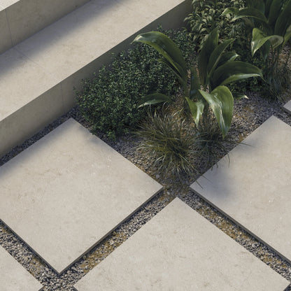 Cifre Cronos 'Cream', crème buitentegels 60x60 van 2 cm als stapstenen in grind tussen planten