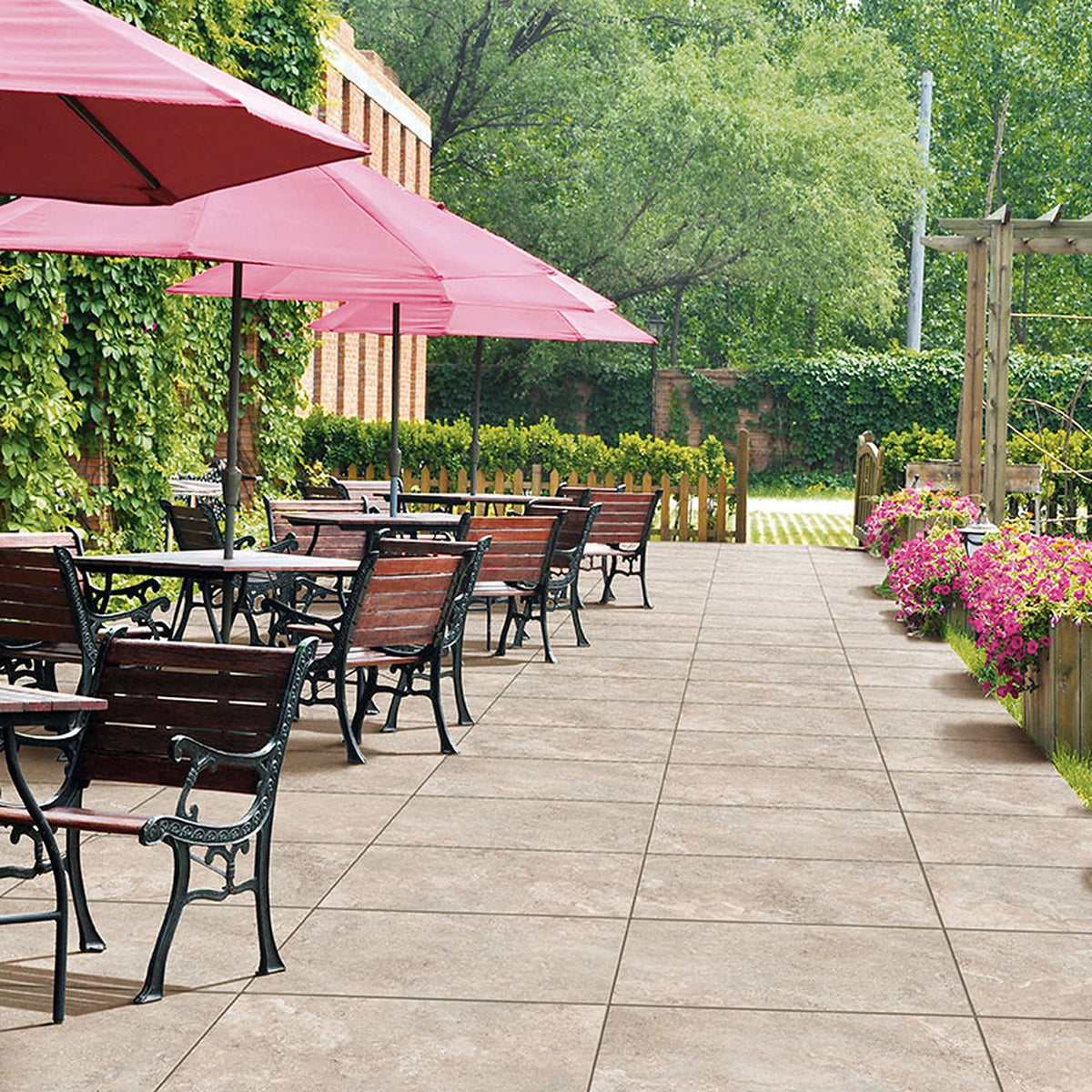 Tuscania Dolomia Stone 'Almond', beige buitentegels, hier 2cm dik in 60x90cm, op een terras met roze parasols