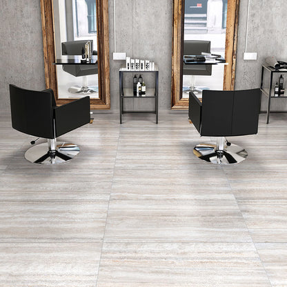 Tuscania Dolomia Stone 'White Vein Cut', lichte vloertegels met lengteaders in een kapsalon met zwarte stoelen en spiegels