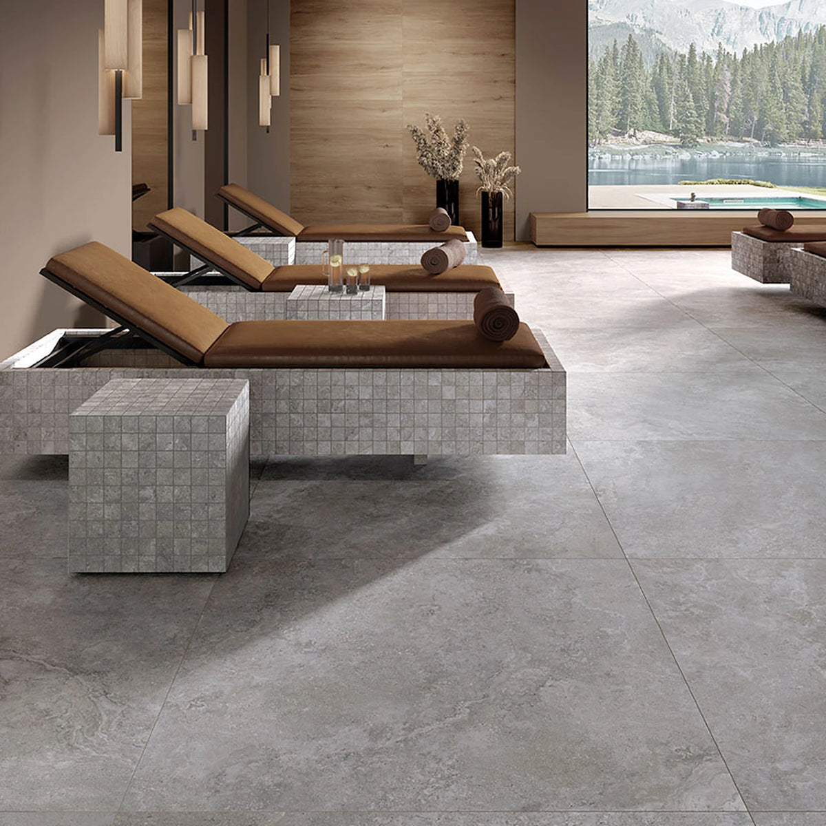 Tuscania Dolomia Stone 'Grey', grijze vloer, hier 122x122cm, in een wellnessruimte met ligbedden en bergmeer