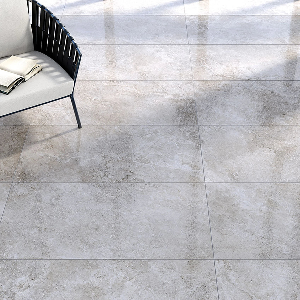 Tuscania Dolomia Stone 'Grey', grijze vloertegels, hier in zijdeglans, met een witte bank met zwarte rugleuning